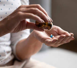 Woman pouring medicine in hand