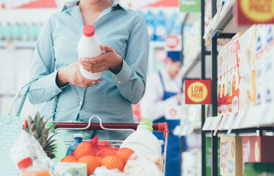 woman reading food label at grocery store